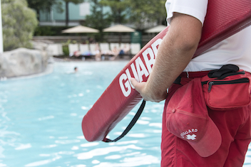 closeup of a lifeguard holding a flotation device.