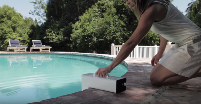 woman kneeling installing a pool alarm.