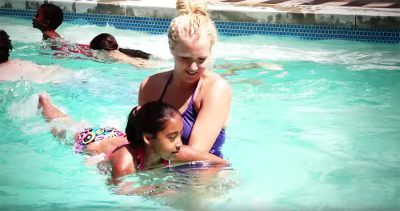 Woman teaching girl to swim