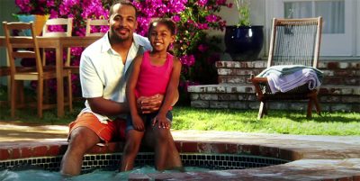 Father and daughter with their toes in a jacuzzi