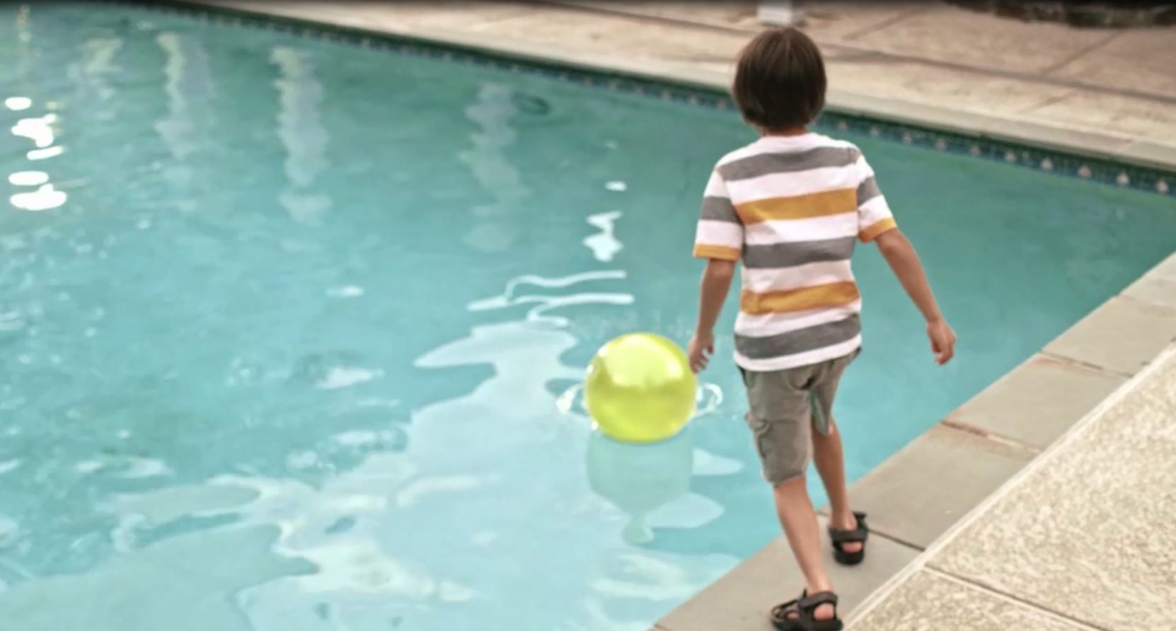 Boy looking at a ball in the pool