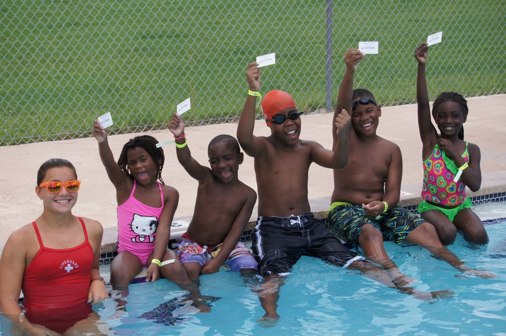 Children proudly show their Learn-to-Swim completion cards that they achieved by participating in swim lessons as part of the American Red Cross Aquatics Centennial Campaign in Brevard County, Florida.