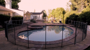 a fence surrounding an in ground pool.