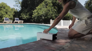 woman kneeling installing a pool alarm.