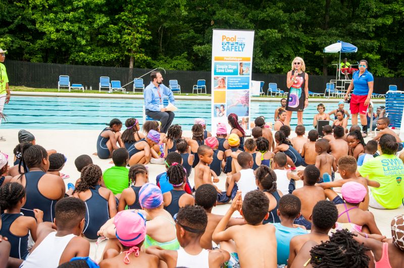 Commisioner Robinson speaking to kids before they get in the water to swim