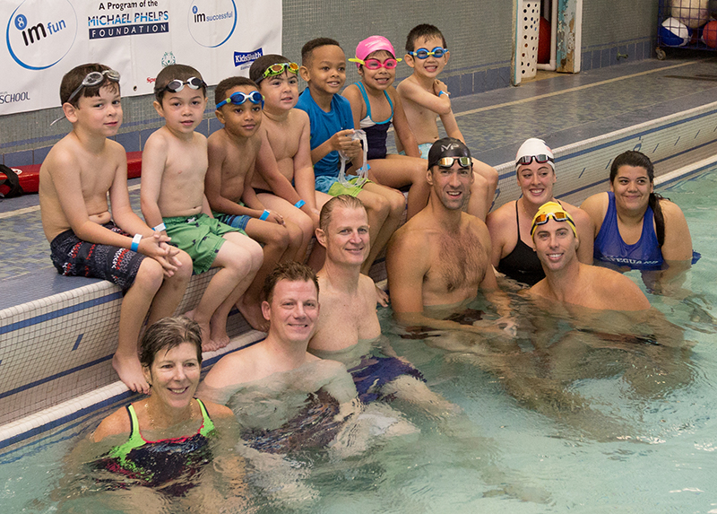 A group of kids with adults in the pool