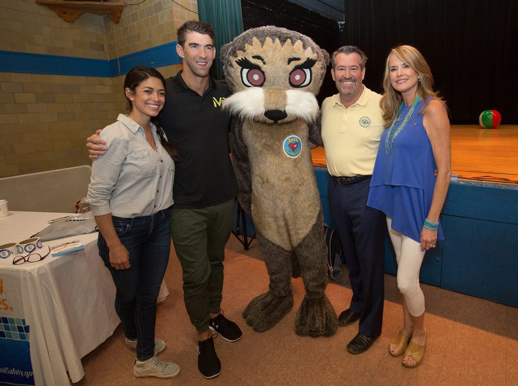 two men and two women standing with a person in an otter costume.
