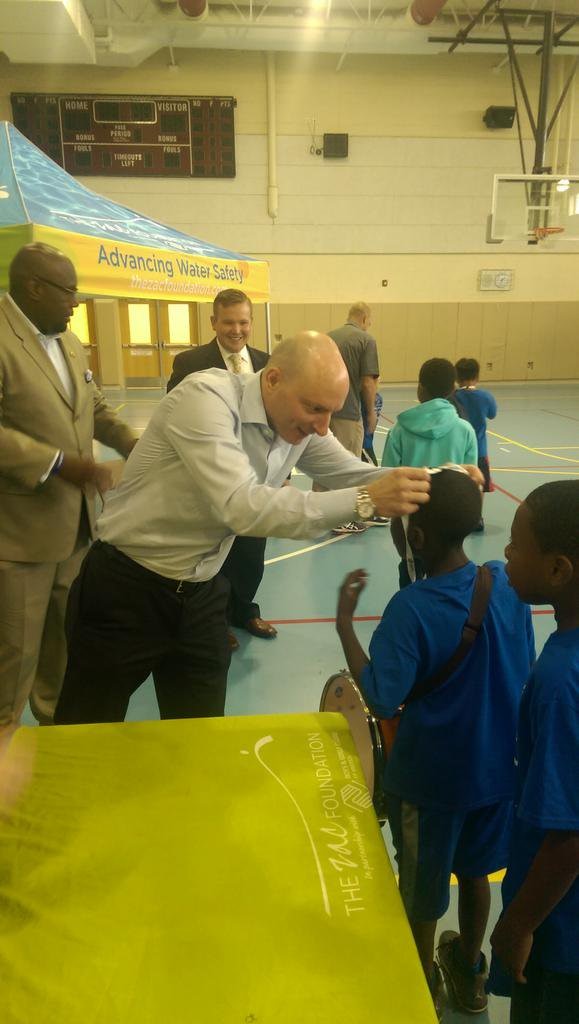 a man puts a medal around a childs neck.