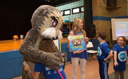 person in an otter costuming hugging a young girl.