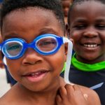 closeup of two African American boys one wearing goggles.