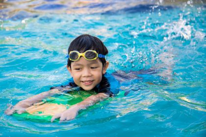 a kid using a kickboard in a pool