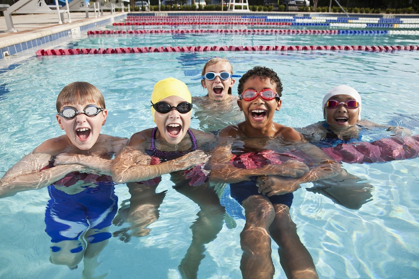 Group of children having fun in swimming pool. Ages 9 to 12 years.