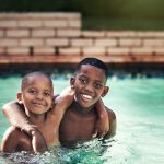 Shot of two young boys having fun together in a swimming pool.