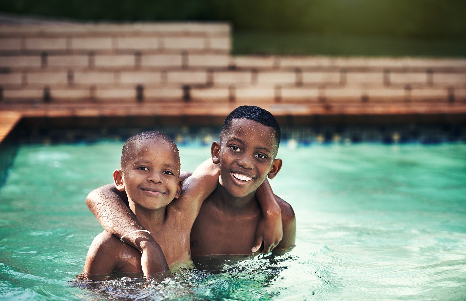 Shot of two young boys having fun together in a swimming pool.