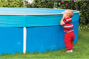 a child looking over the side of an above ground pool.