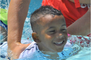 closeup of a young boy swimming.