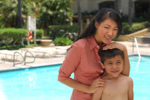 a mother and son next to a pool.