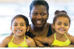 an adult woman with two small children in a pool.