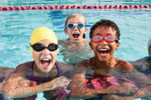 three children smiling in the water.