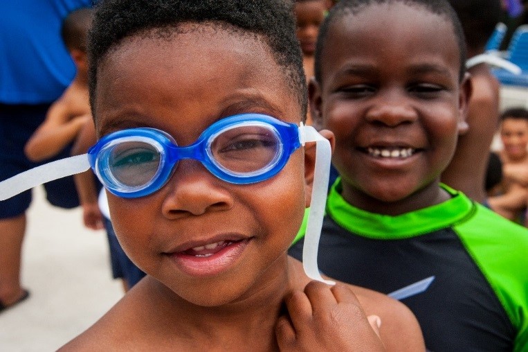 closeup of two boys, one wearing blue googles.