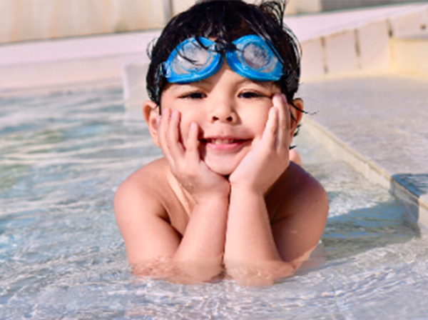 young boy with his head in his hands in a pool.