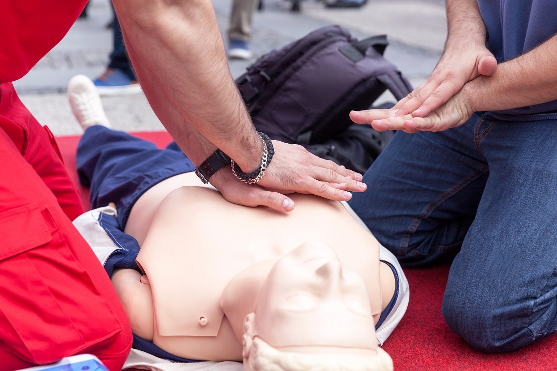 Instructor Teaching Cpr On Dummy.