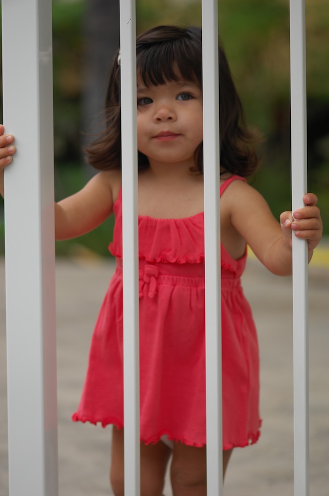 kid behind pool fence