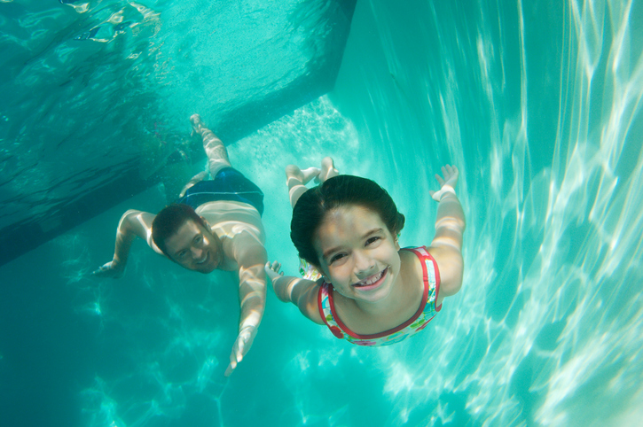 Father and daughter swimming, underwater view