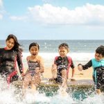 kids splashing water with their feet at the beach