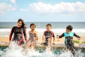 kids splashing water with their feet at the beach